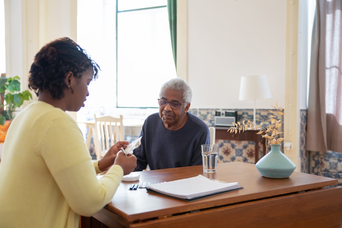 A caregiver gently supporting an elderly parent at home, demonstrating compassionate in-home care in Maine