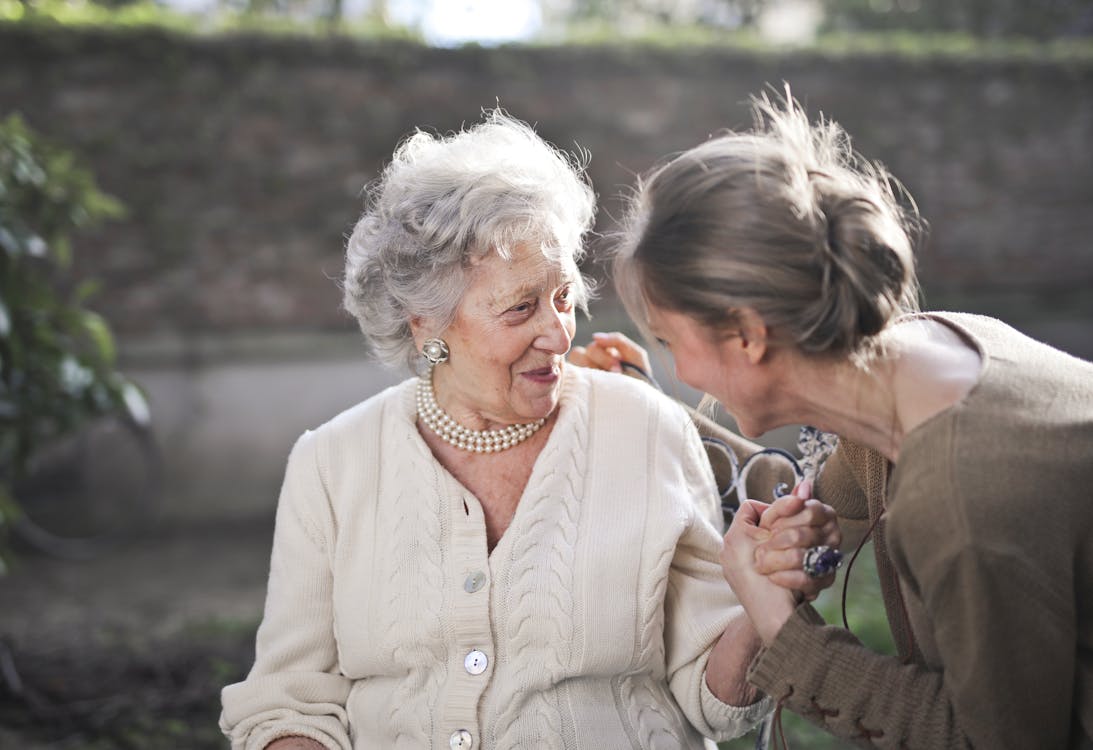 Elderly woman sitting peacefully at home, reflecting — recognizing early signs that a senior parent may need support in Maine